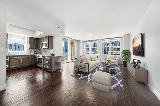 a living room with furniture flat screen tv and wooden floor