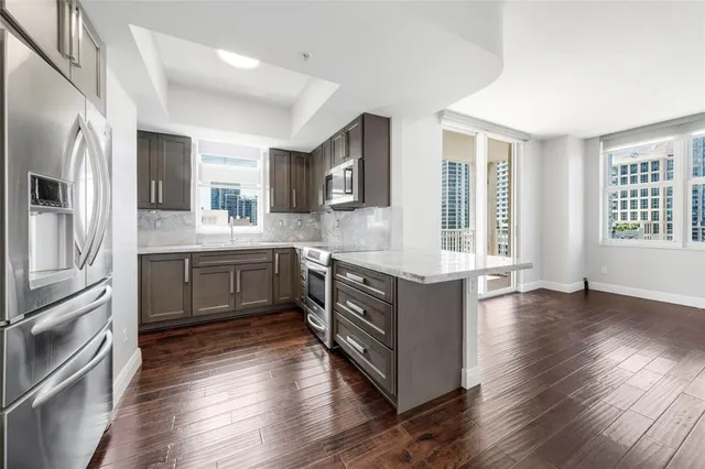 a kitchen with stainless steel appliances granite countertop a sink a stove and a refrigerator