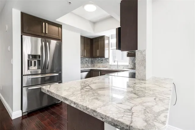 a kitchen with granite countertop a refrigerator and stove