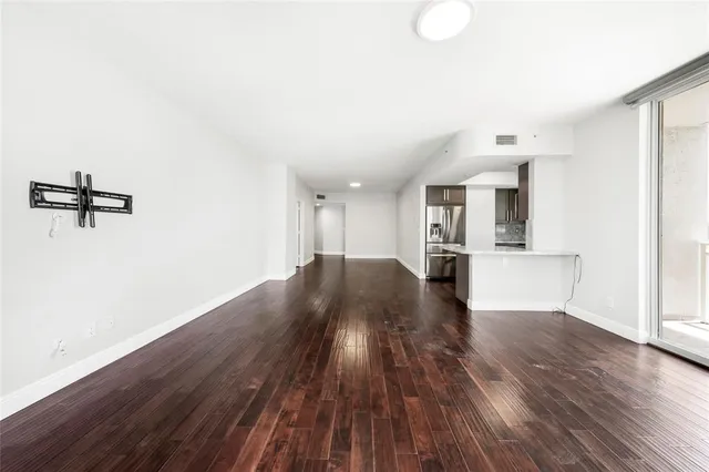 a view of a room with wooden floor and a kitchen