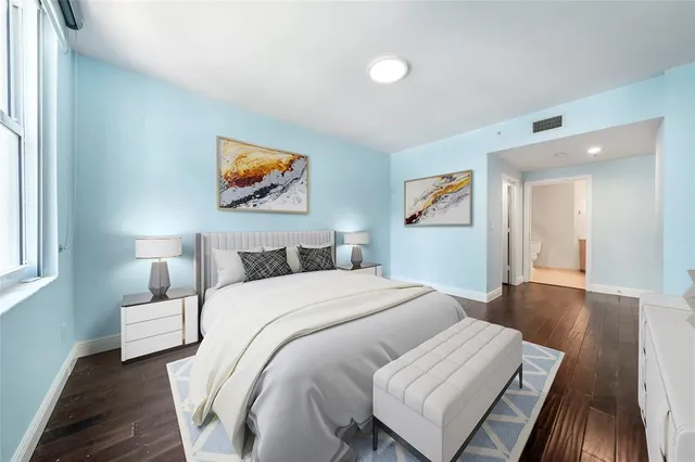 a bedroom with a bed and a painting on the wall