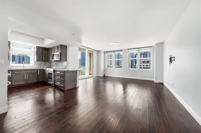 a view of a big room with wooden floor and a kitchen
