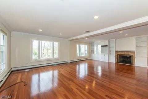 an empty room with wooden floor and fireplace