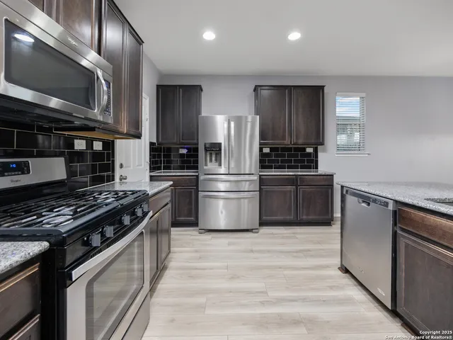 a kitchen with stainless steel appliances a refrigerator a stove and a sink