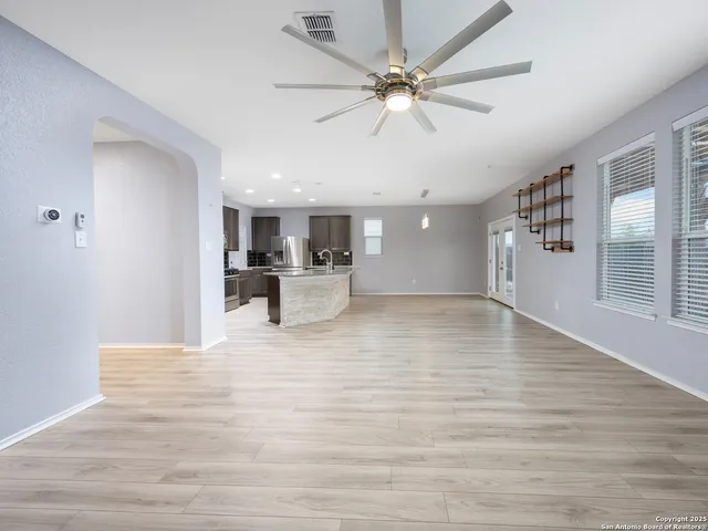 a view of a livingroom with a ceiling fan window and wooden floor