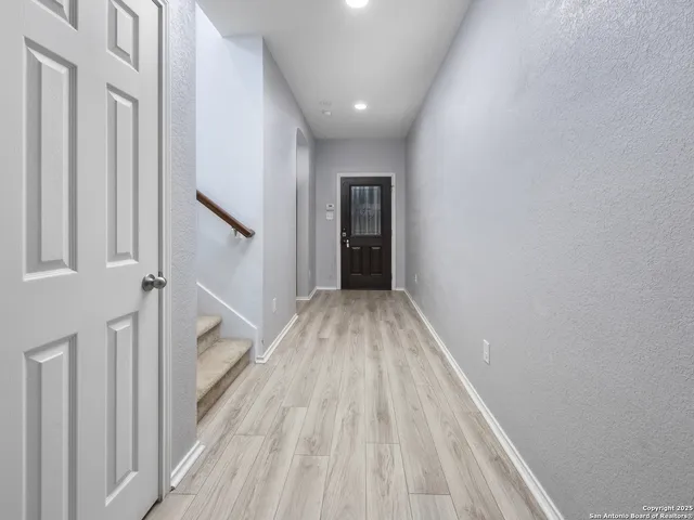 a view of a hallway with wooden floor and staircase