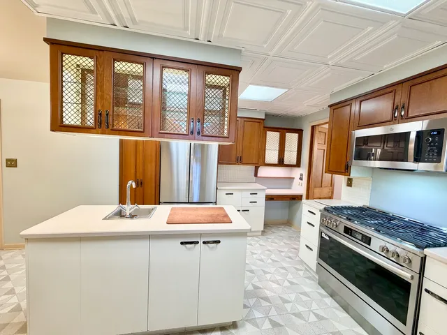 a kitchen that has a sink a stove and a refrigerator