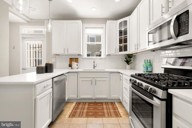 a kitchen with stainless steel appliances a stove a sink and a microwave