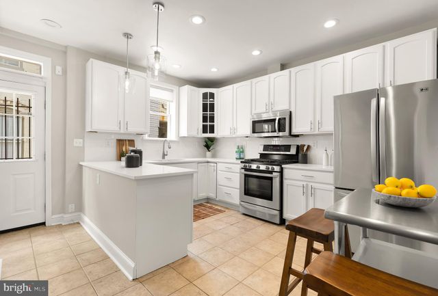 a kitchen with white cabinets and stainless steel appliances
