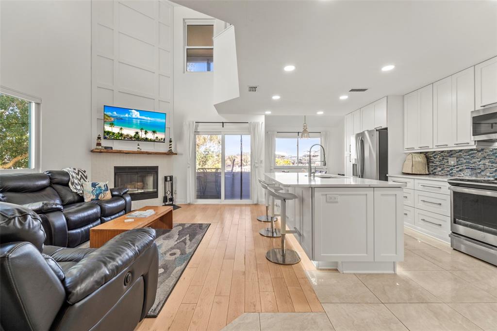 2385 Hanover Drive Dunedin, FL 34698 - Photo 3 of 87 a living room with furniture a fireplace and a flat screen tv