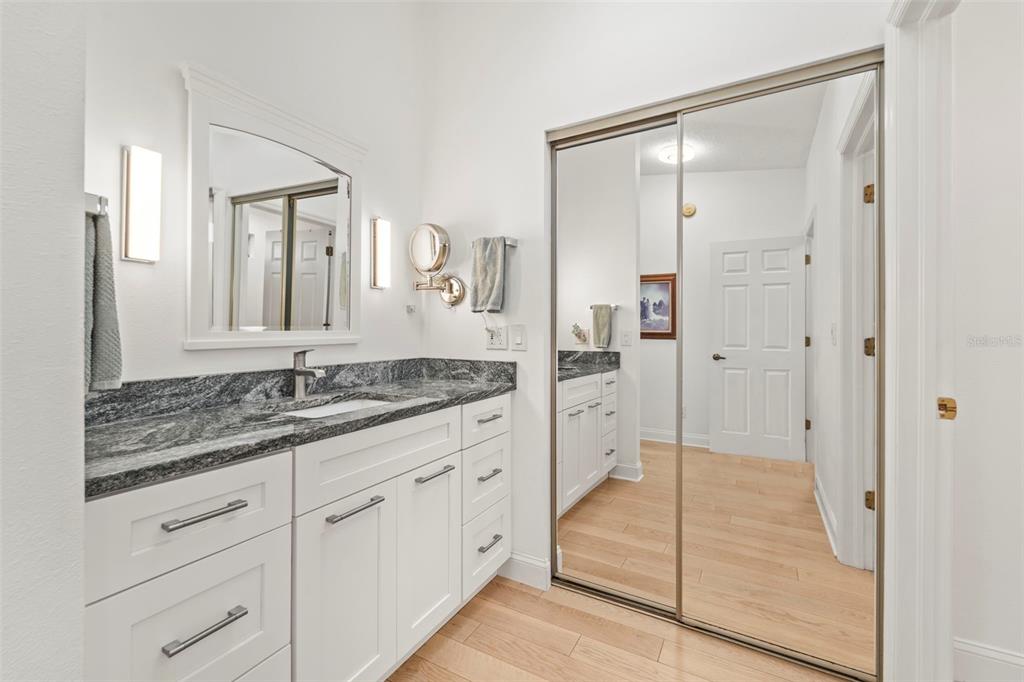 2385 Hanover Drive Dunedin, FL 34698 - Photo 44 of 87 a bathroom with a granite countertop sink two mirror and a shower