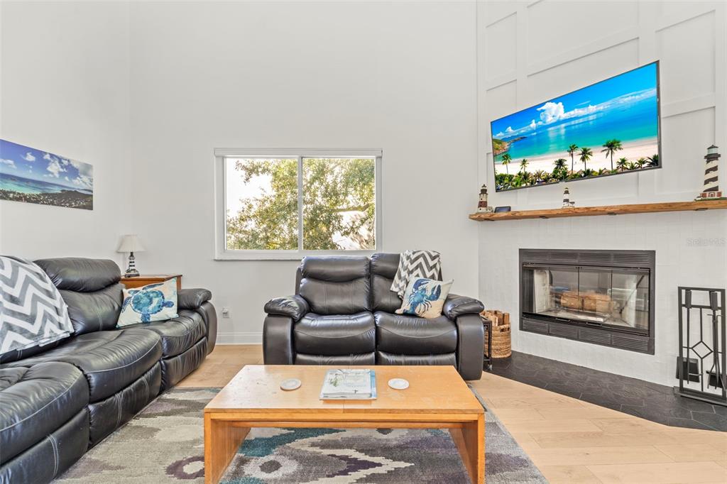2385 Hanover Drive Dunedin, FL 34698 - Photo 6 of 87 a living room with furniture and a fireplace