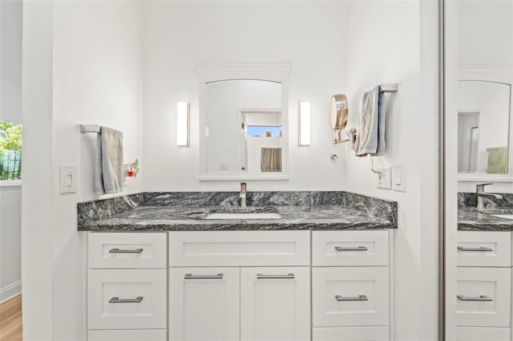 2385 Hanover Drive Dunedin, FL 34698 - Photo 64 of 87 a bathroom with a granite countertop sink and a mirror