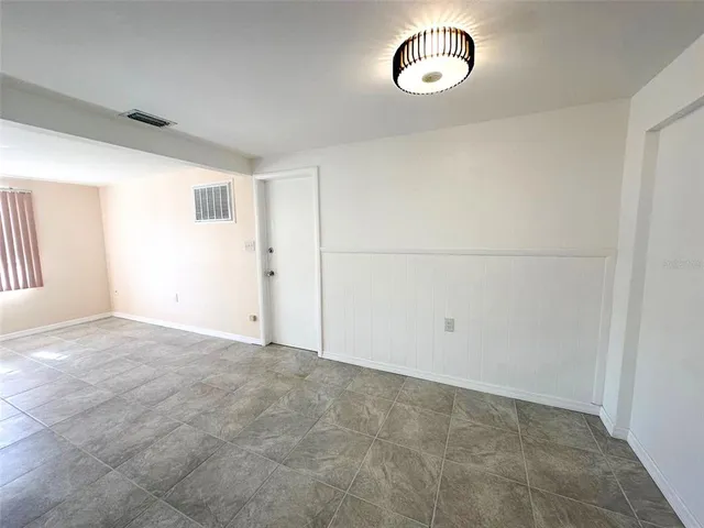 an empty room with wooden floor and stairs