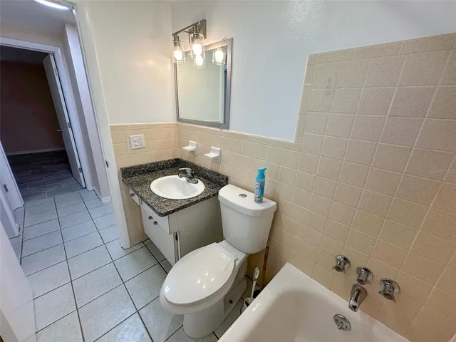 a view of an empty room with wooden floor and stairs