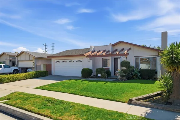 a front view of a house with a yard and potted plants