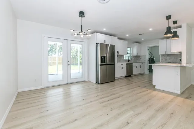a view of a kitchen with stainless steel appliances granite countertop a refrigerator and a stove top oven