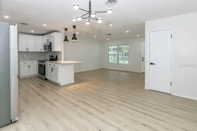 a view of kitchen with stove and cabinets
