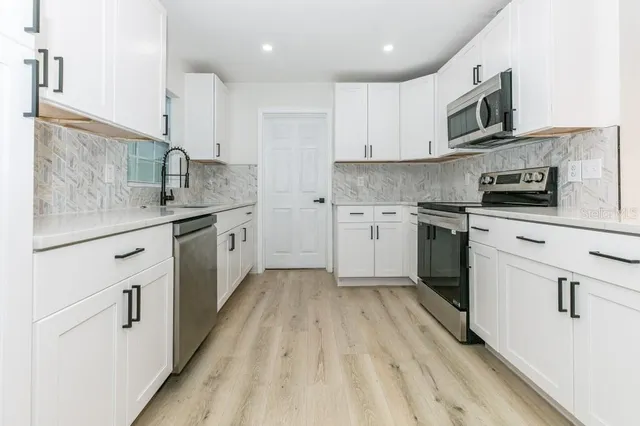 a kitchen with stainless steel appliances granite countertop a sink stove and refrigerator