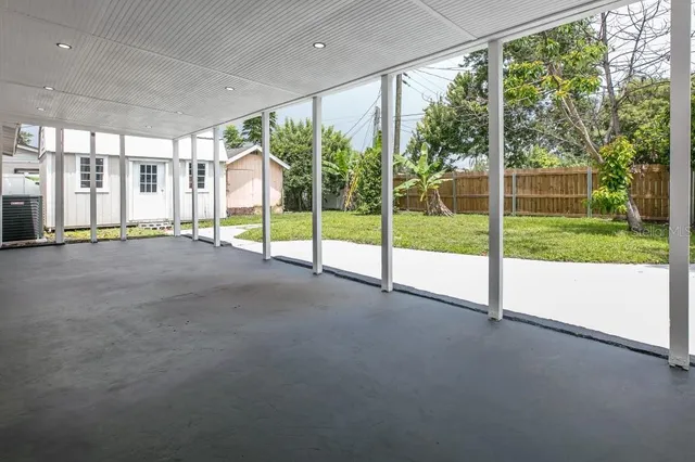 a view of a backyard with potted plants and large tree