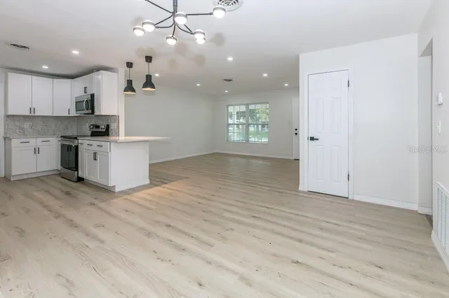 a large kitchen with kitchen island a sink stainless steel appliances and cabinets