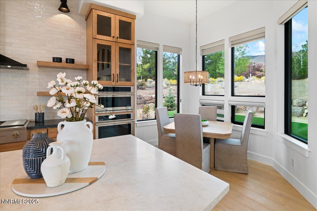 10755 Renegade Court Reno, NV 89511 - Photo 21 of 60 a dining room with furniture a large window and potted plants