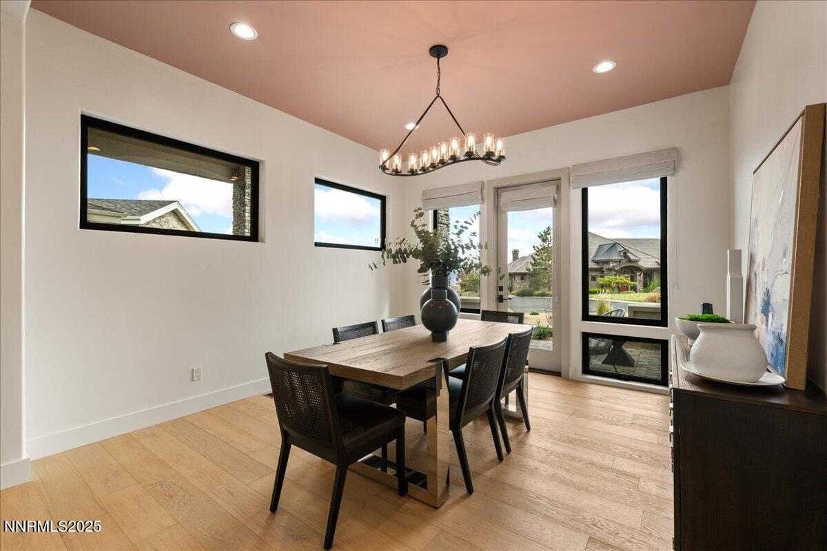 10755 Renegade Court Reno, NV 89511 - Photo 24 of 60 a dining room with wooden floor a chandelier a wooden table and chairs
