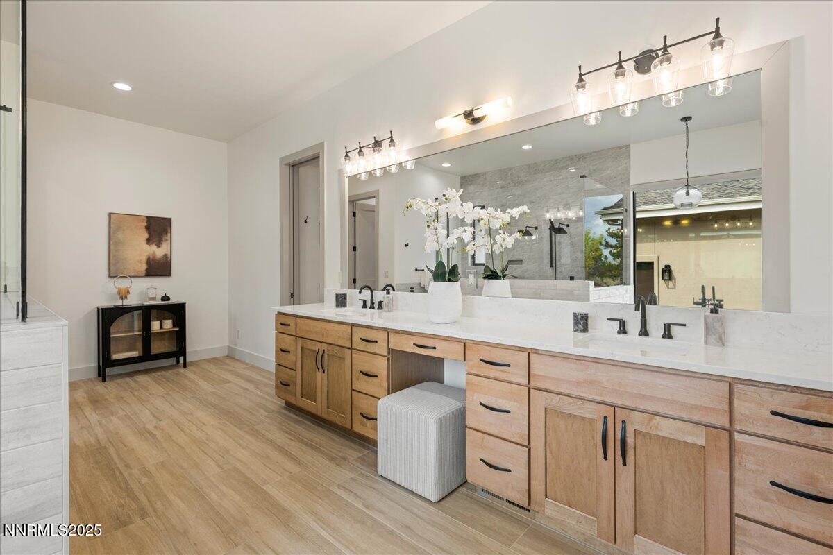 10755 Renegade Court Reno, NV 89511 - Photo 29 of 60 a spacious bathroom with a double vanity sink a mirror and a shower