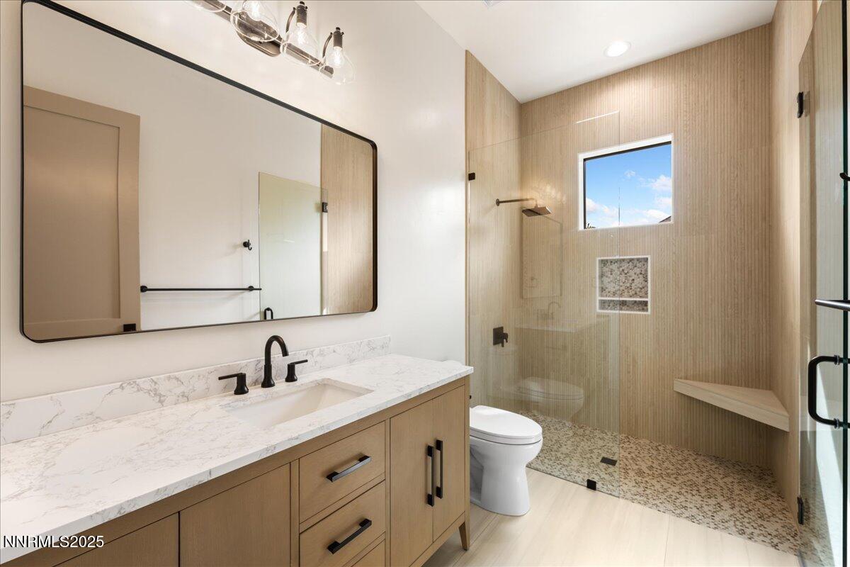 10755 Renegade Court Reno, NV 89511 - Photo 41 of 60 a bathroom with a toilet a sink a mirror and a shower