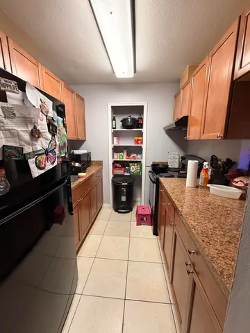 a kitchen with stainless steel appliances granite countertop a refrigerator and a stove