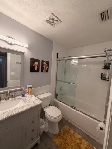 a spacious bedroom with a bed and a chandelier