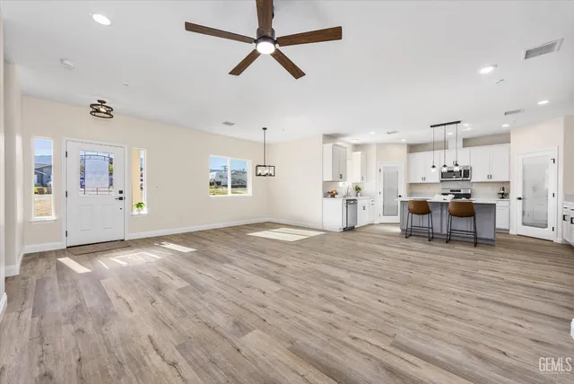 a view of a kitchen with wooden floor and a ceiling fan
