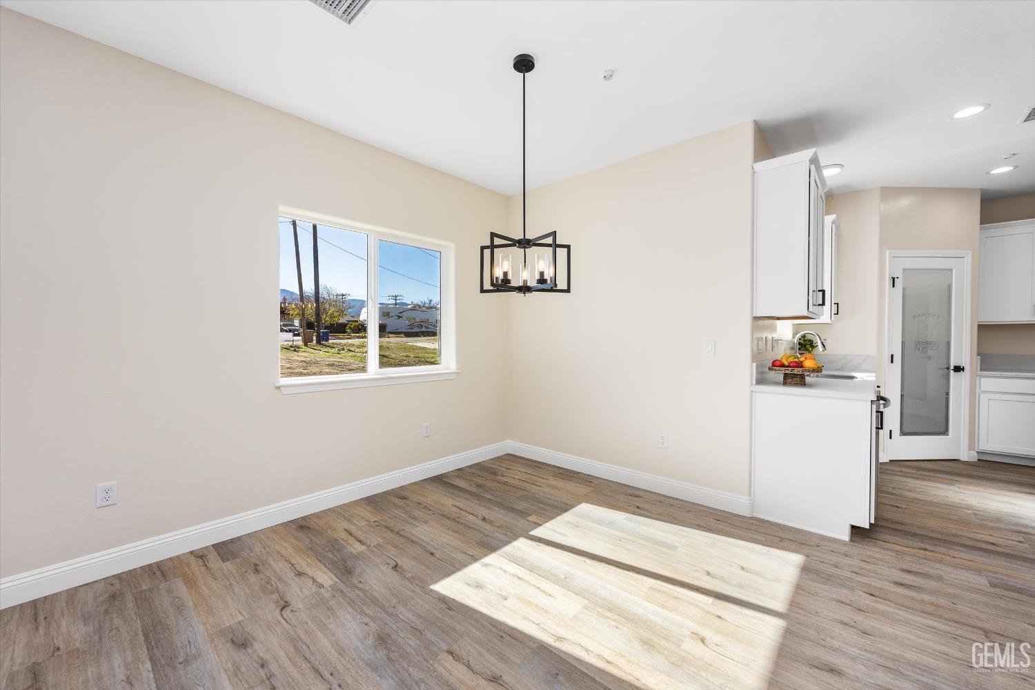 Undisclosed Address Tehachapi, CA 93561 - Photo 18 of 50 a view of a kitchen with wooden floor and a ceiling fan