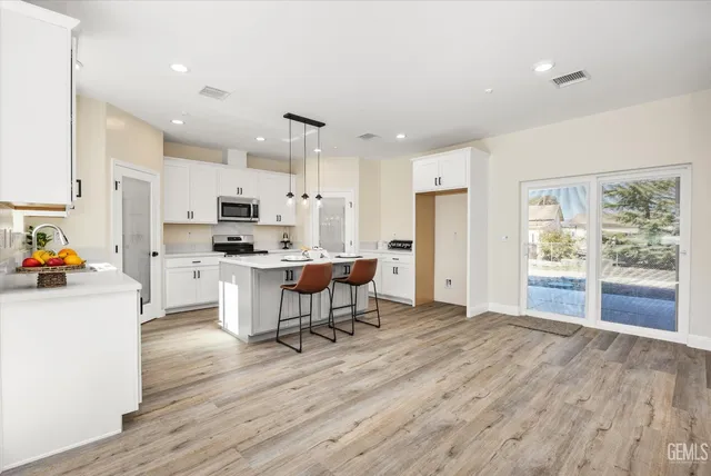 a kitchen with a sink a stove and white cabinets