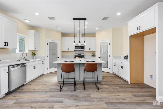 a kitchen with a sink a stove a refrigerator and cabinets