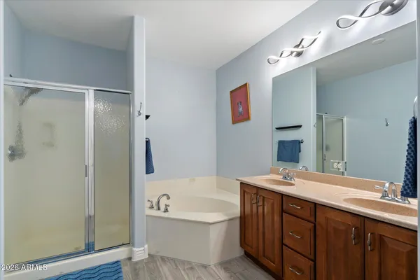 a bathroom with a tub a sink and a large mirror