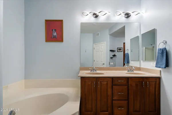 a bathroom with a tub sink and mirror
