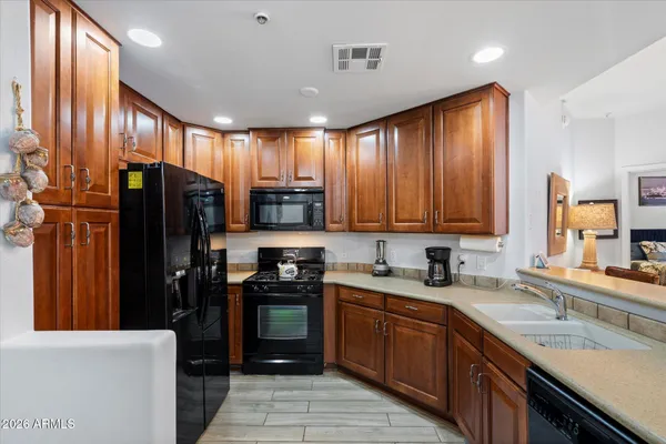 a kitchen with stainless steel appliances granite countertop refrigerator a sink a stove top oven and large counter space