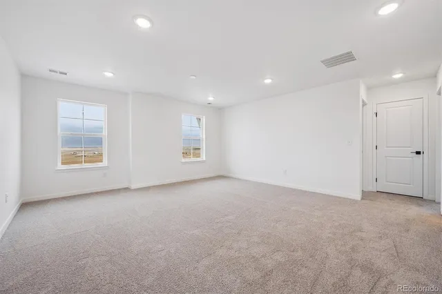 an empty room with windows and closet