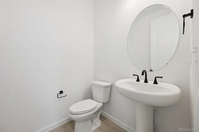 a bathroom with a sink a toilet and mirror
