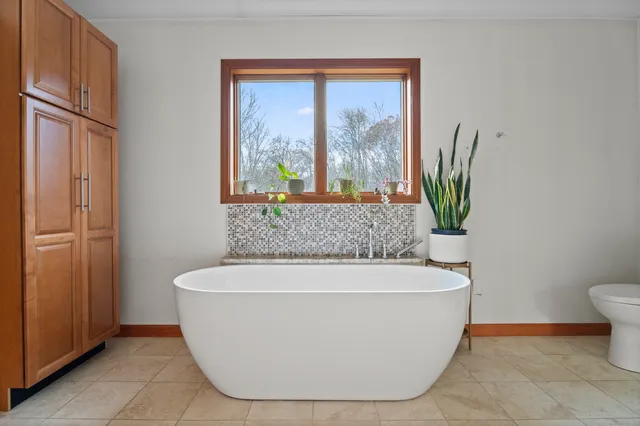 a bedroom with a bed a window and chair