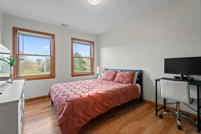 a bathroom with a granite countertop sink toilet and painting on the wall