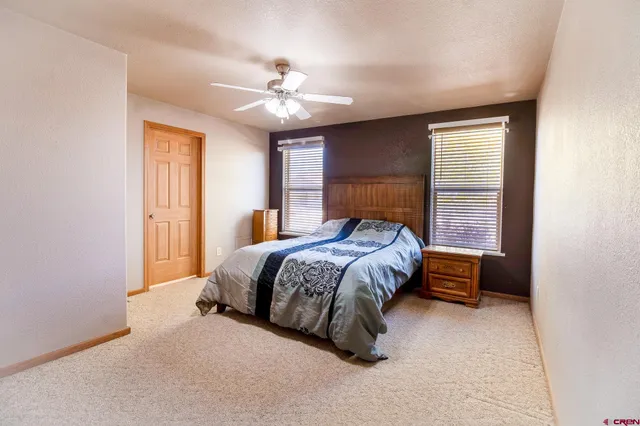 a bedroom with a large bed and a ceiling fan