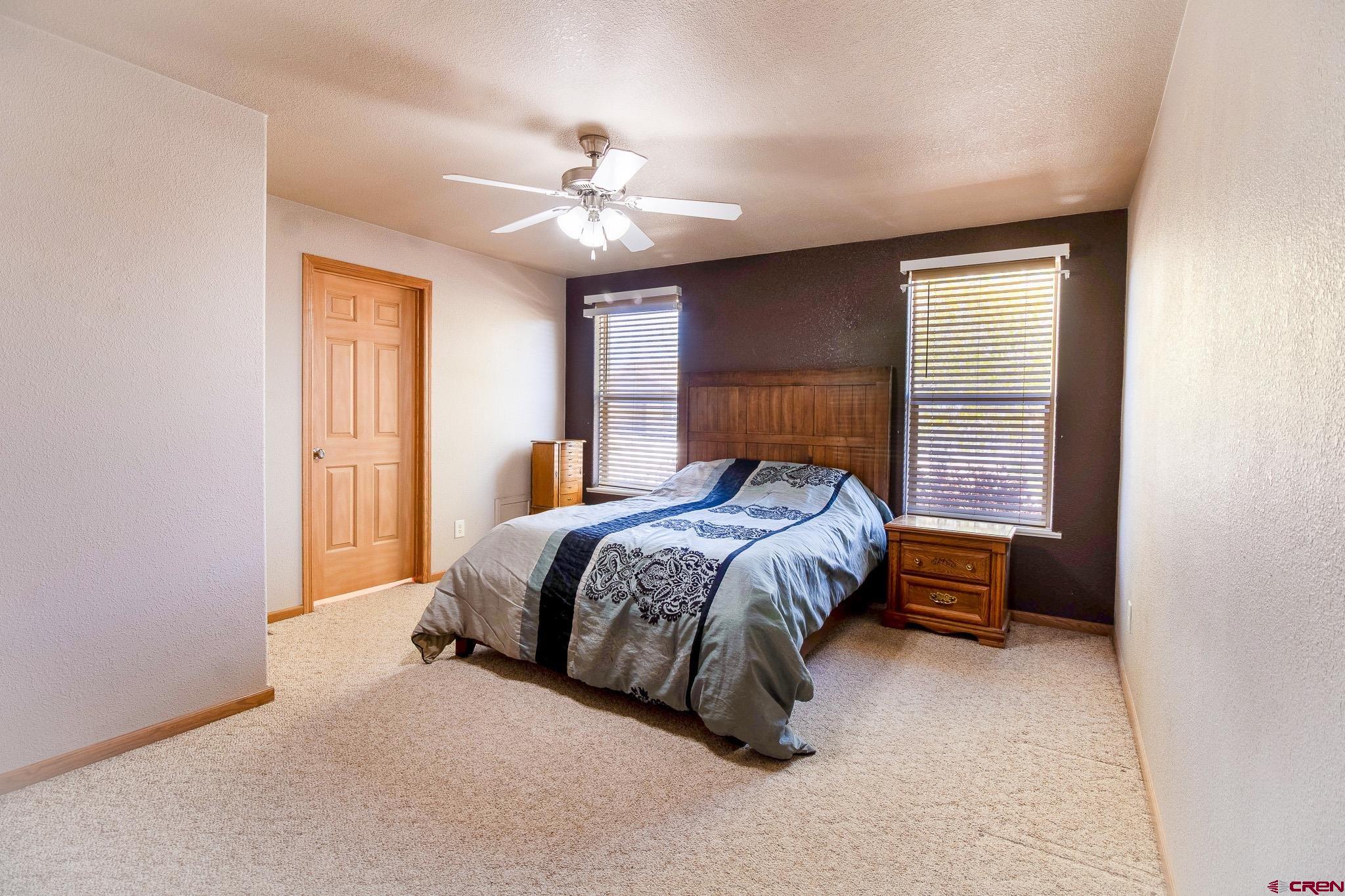 801 L Way Cortez, CO 81321 - Photo 16 of 41 a bedroom with a large bed and a ceiling fan
