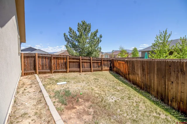 a view of a backyard with wooden fence