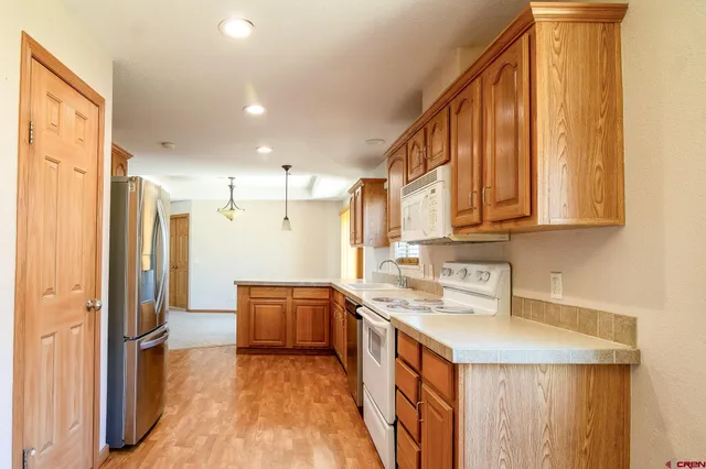 a kitchen with stainless steel appliances granite countertop a sink a stove a refrigerator and cabinets