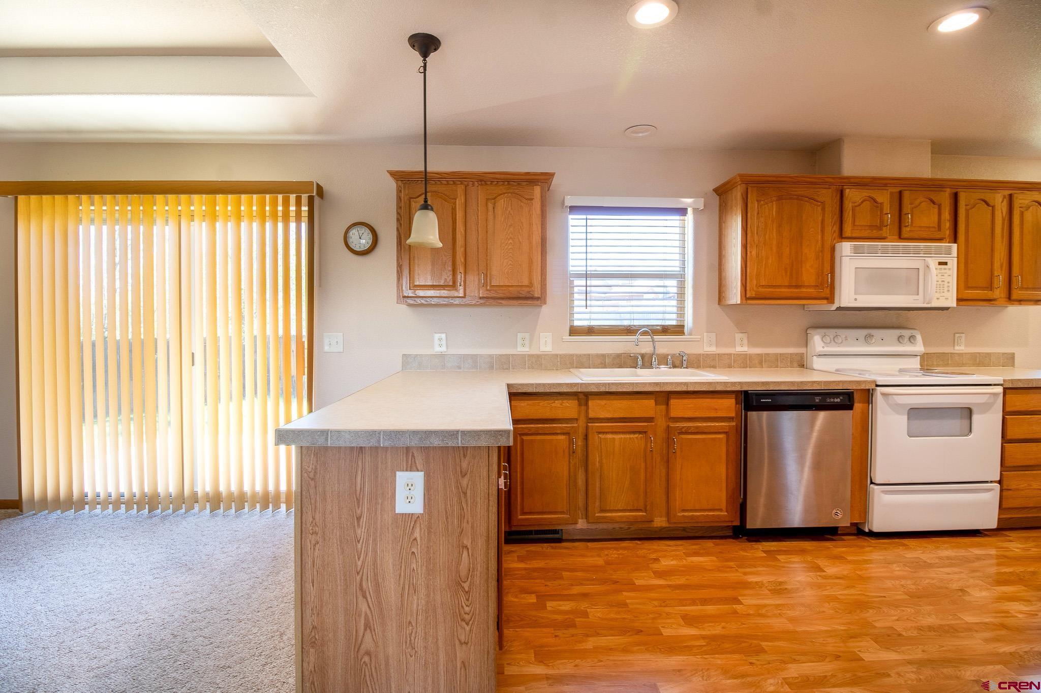 801 L Way Cortez, CO 81321 - Photo 9 of 41 a kitchen with stainless steel appliances granite countertop a sink a stove and a refrigerator