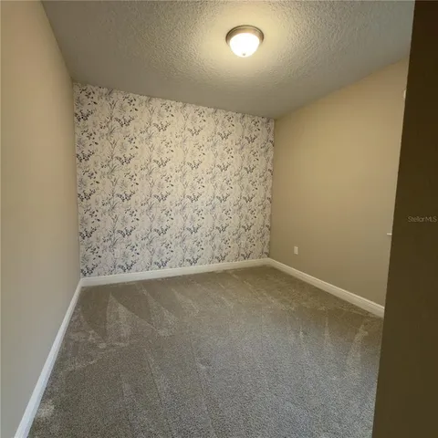 an empty room with a wooden wall and shower