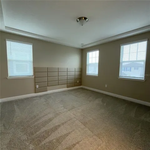an empty room with windows and cabinet