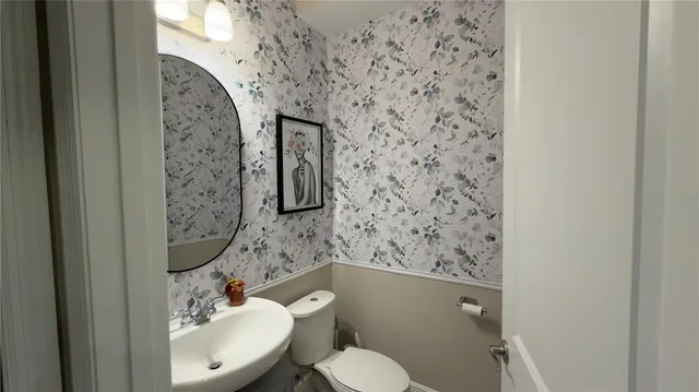 a bathroom with a toilet sink and mirror